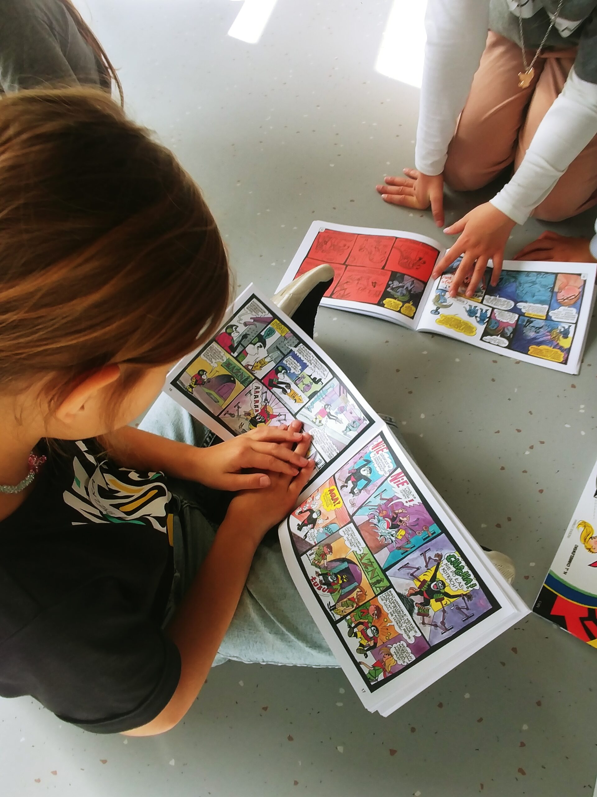 20241001_140531 Zdjęcie wykonane podczas warsztatów Z książką w walizce przedstawiające uczennice czytające komiksy